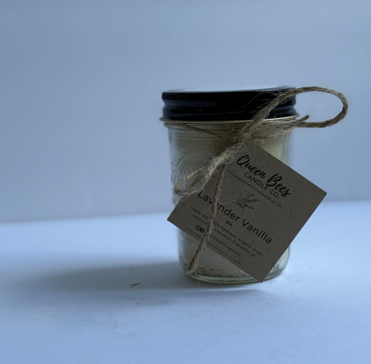 Small glass jar with a black lid on a white surface with a light blue background